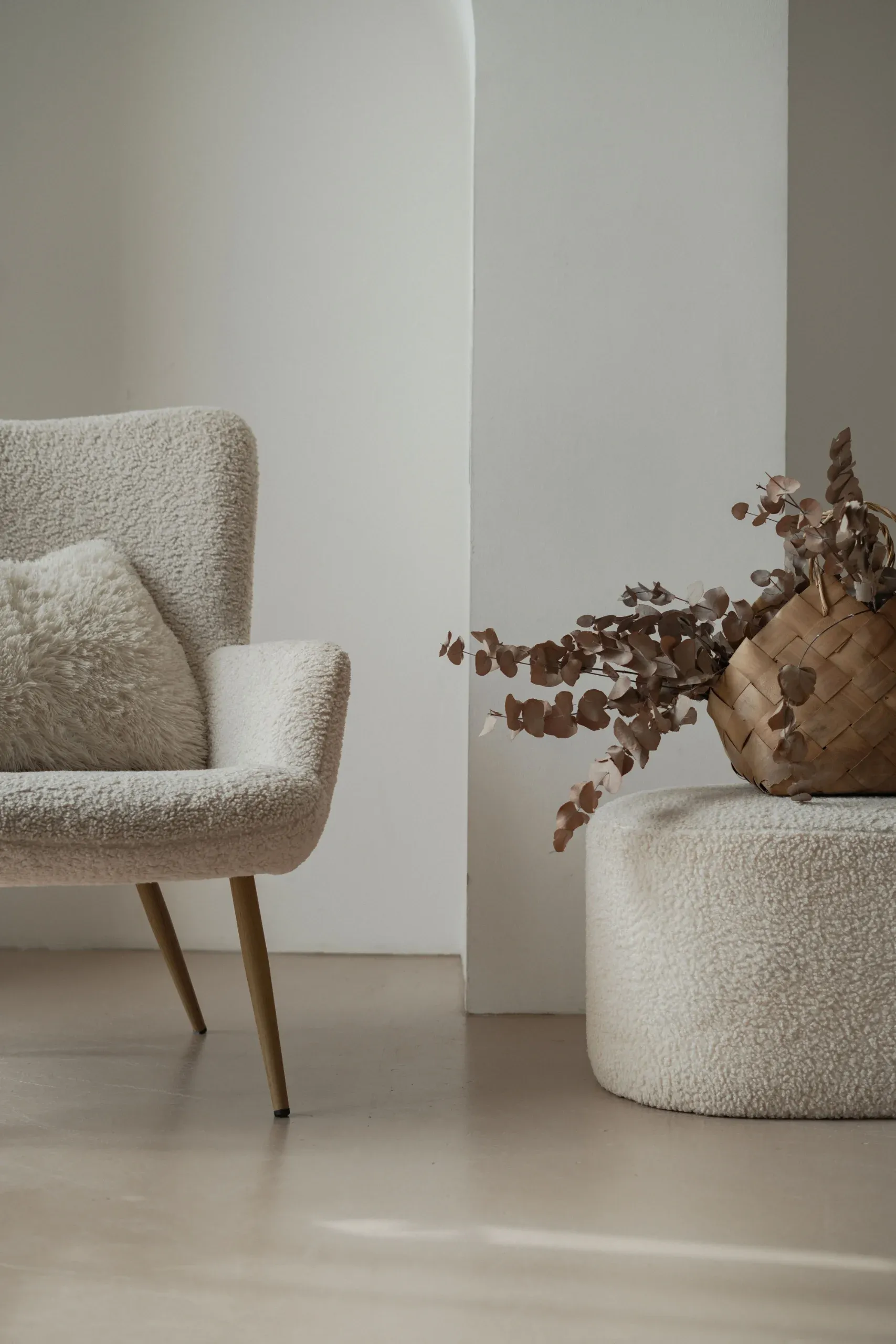 Mère assise sur un divan beige, son nouveau-né endormi dans les bras