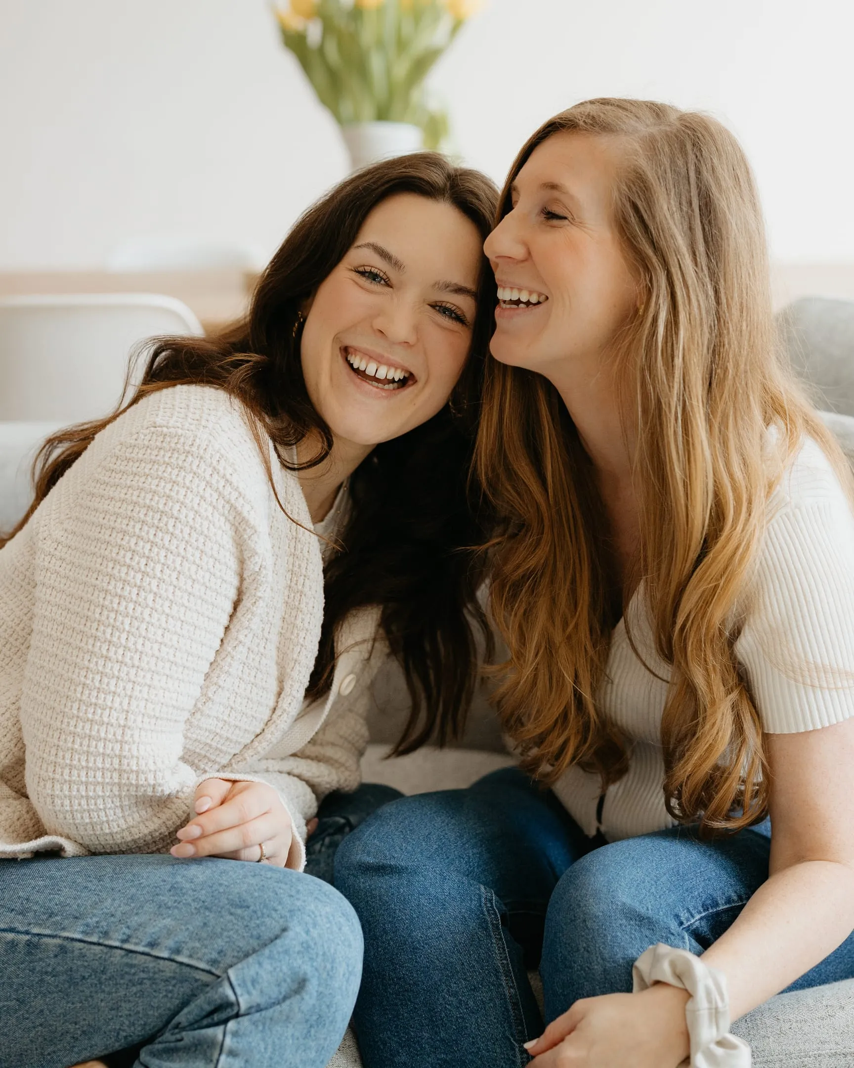 Daphné et Vicki riant ensemble, assises sur un divan clair