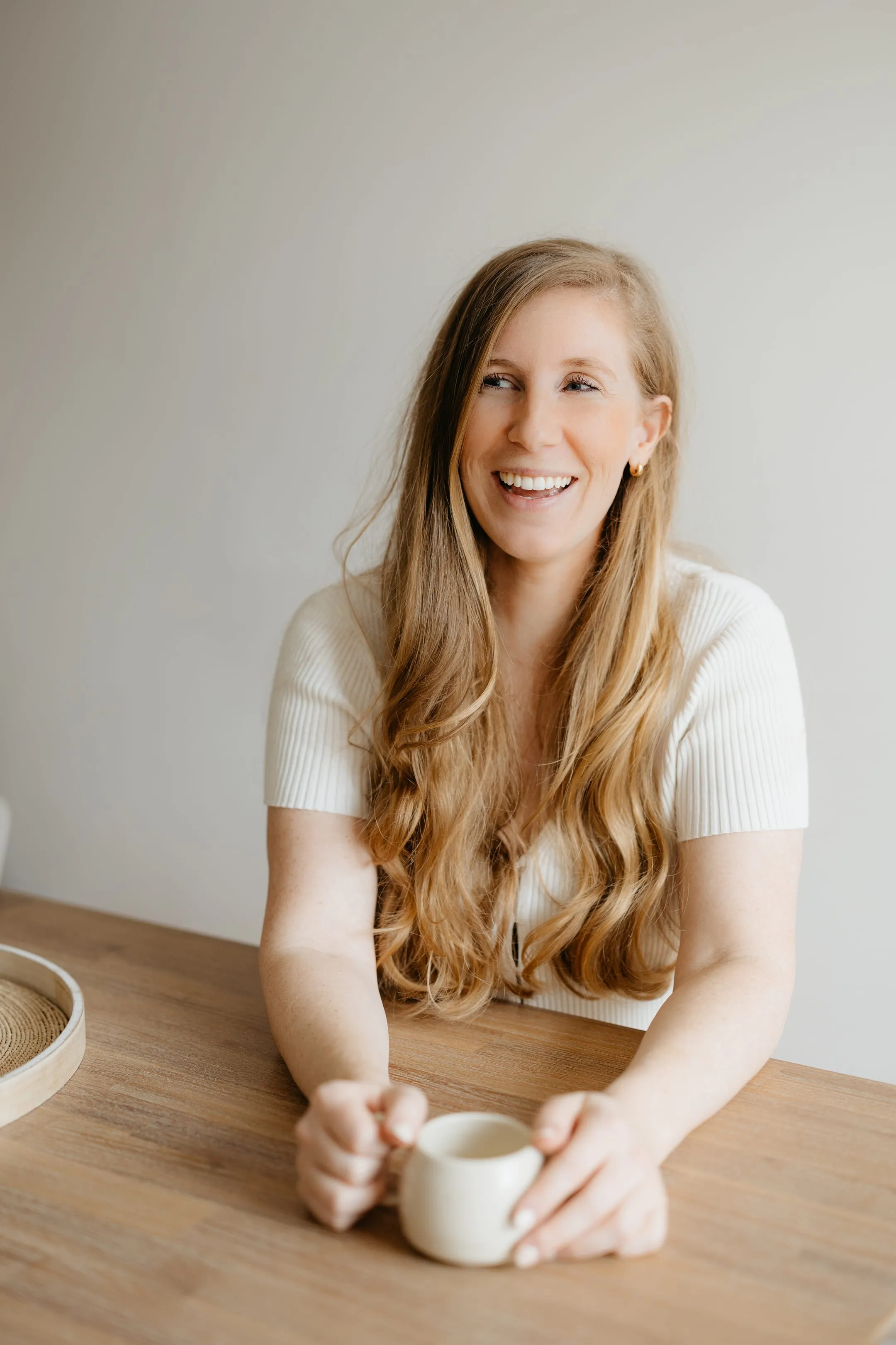 Portrait de Vicki Langelier, attablée avec une tasse, souriante