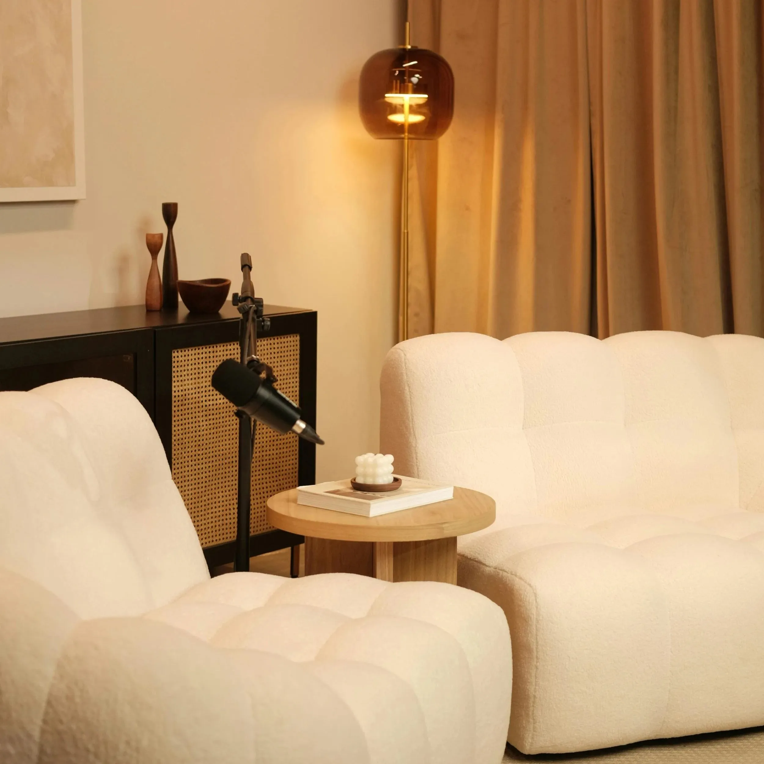 Coin d’enregistrement du Podtalk : fauteuils bouclés crème, micro sur pied et lampe ambrée